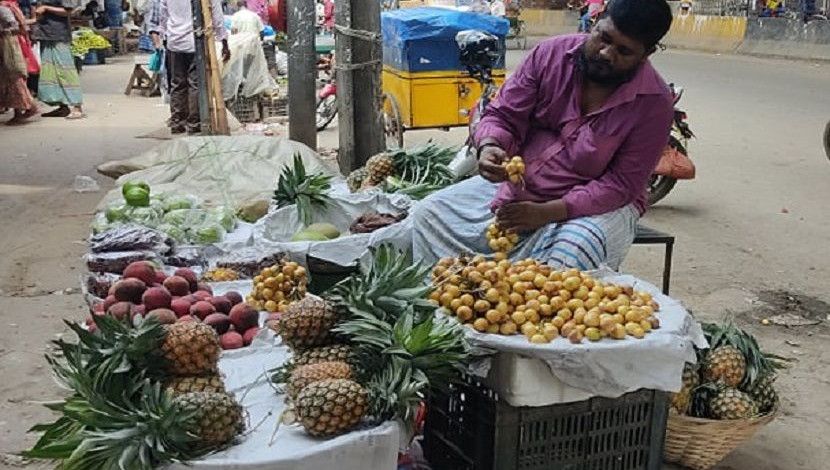 মৌসমী ফল বিক্রি করছেন এক ক্ষুদ্র ব্যবসায়ী। লকডাউনেও খুলে বসেছেন দোকান। প্রশ্ন করলে জানান, অর্থের অভাবে দোকান খুলতে বাধ্য হয়েছেন তিনি। ছবি: জাহিদ রকিব