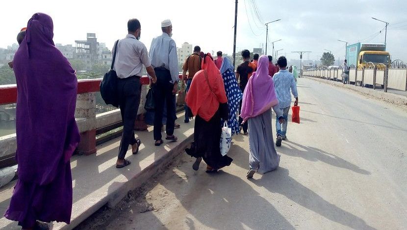 লকডাউনের কারণে গণপরিবহন না থাকায় পায়ে হেঁটে রাজধানীতে প্রবেশ করছে মানুষ।  ছবি- মেহেদী হাসান রাজু, স্থান- গাবতলী ব্রিজ।