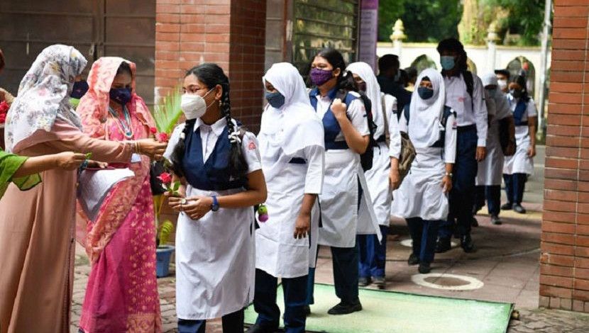 শিক্ষার্থীরা স্কুলে ফিরেছে। দীর্ঘ প্রায় দেড় বছর পর স্কুলে ফেরার দিনে ফুল দিয়ে তাদের বরণ করে নেয়া হয়। ছবি: পিয়াস বিশ্বাস